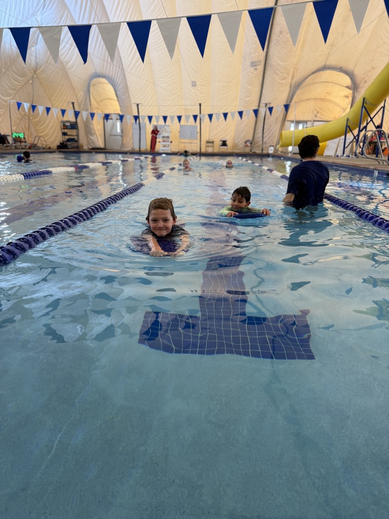 An instructor helps children learn to swim.