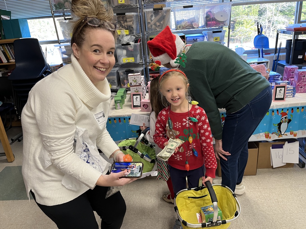 Volunteers help students at a PTO-run holiday shop.