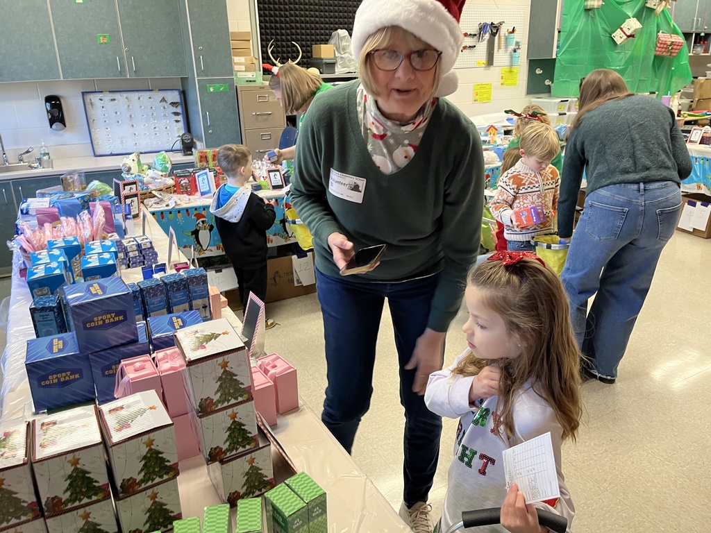 Volunteers help students at a PTO-run holiday shop.