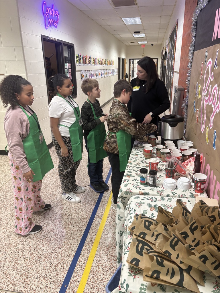Students get hot chocolate at a table.