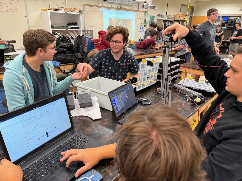 Robotics team members work on robots.