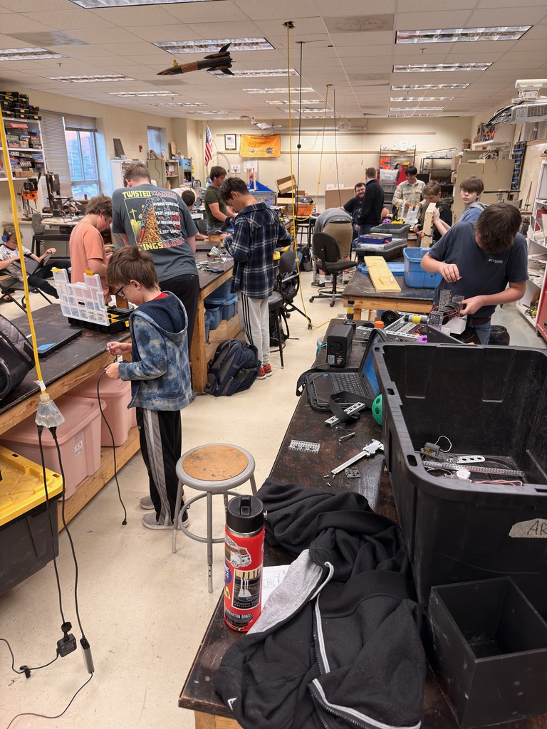 Robotics team members work on robots.