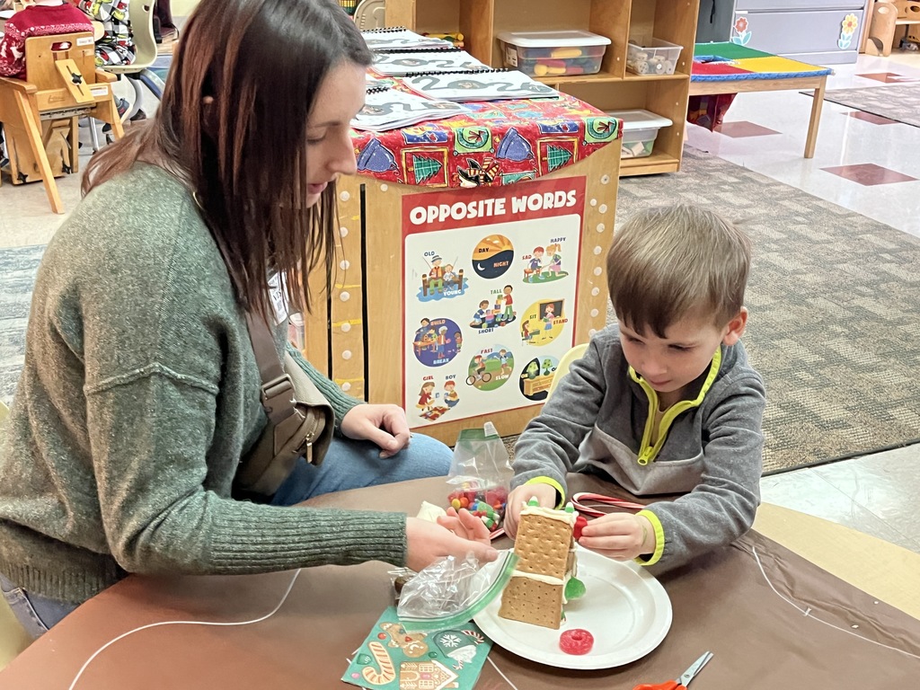 An adult and child work on a personal gingerbread house.