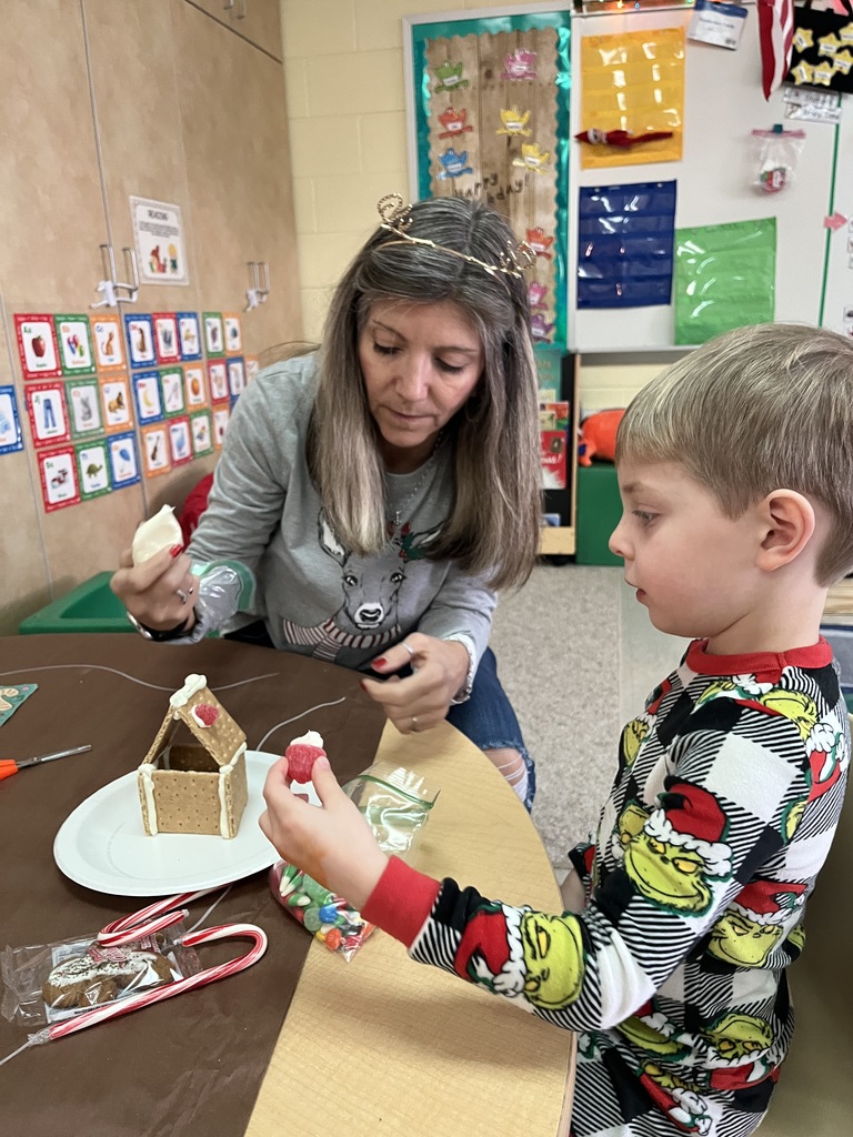 An adult and child work on a personal gingerbread house.