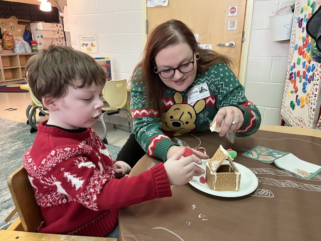An adult and child work on a personal gingerbread house.