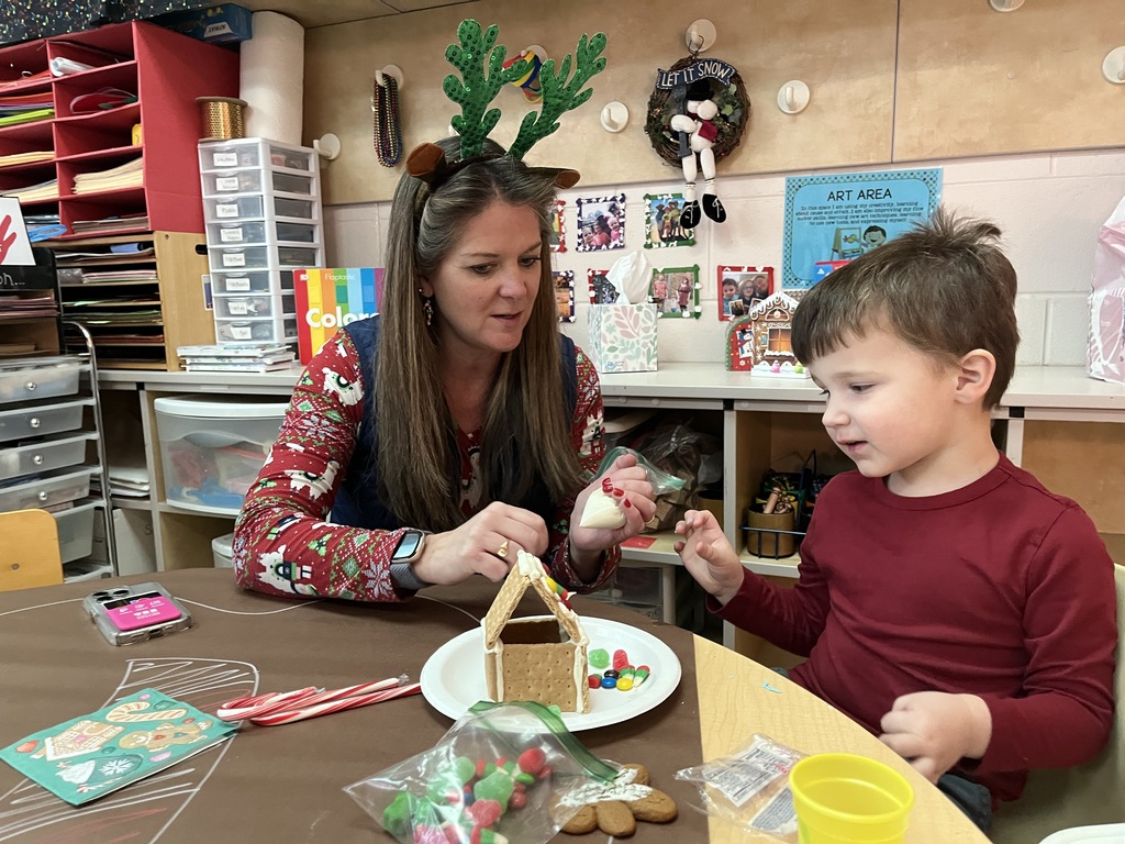 An adult and child work on a personal gingerbread house.