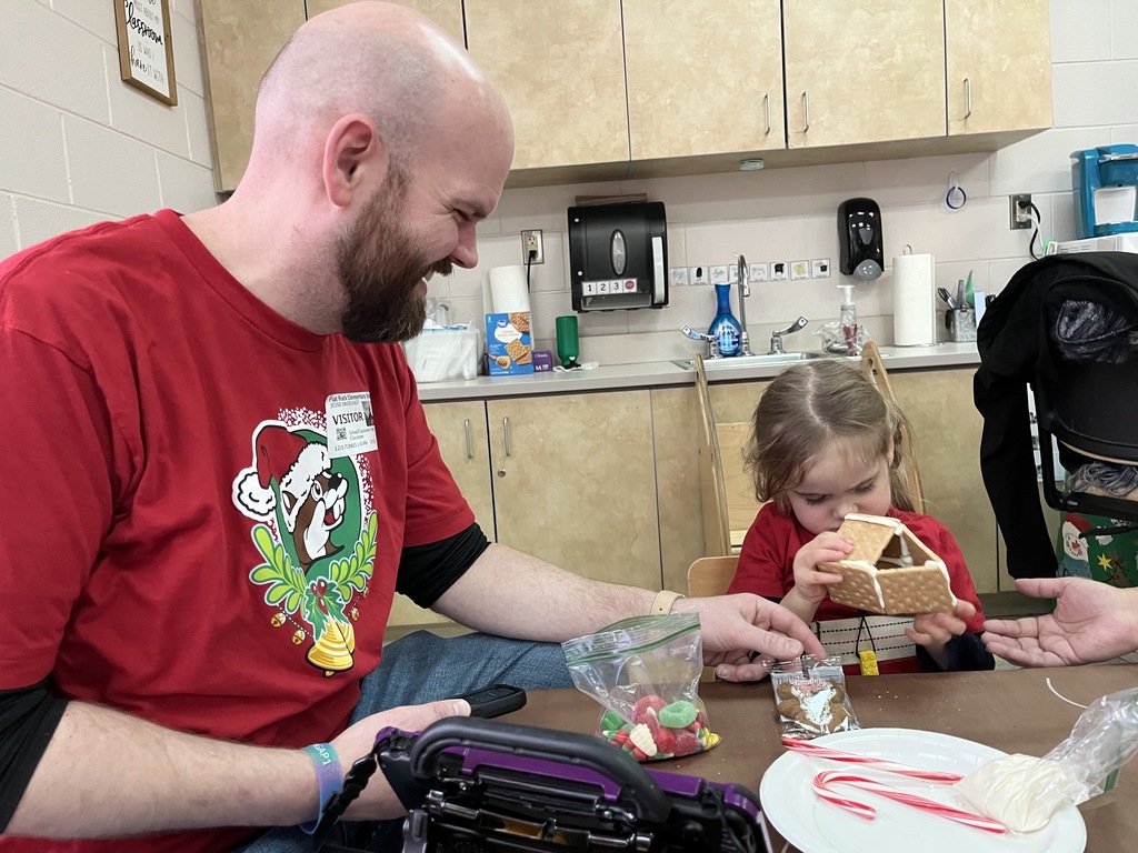 An adult and child work on a personal gingerbread house.