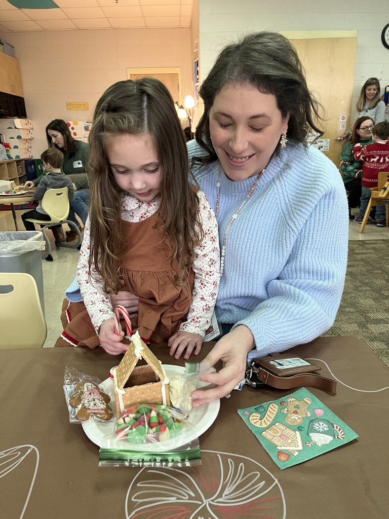 An adult and child work on a personal gingerbread house.