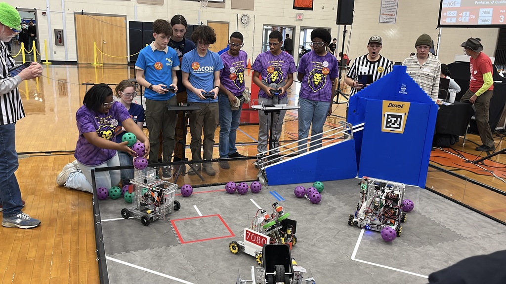 Robotics teams compete in a match at a robotics competition.