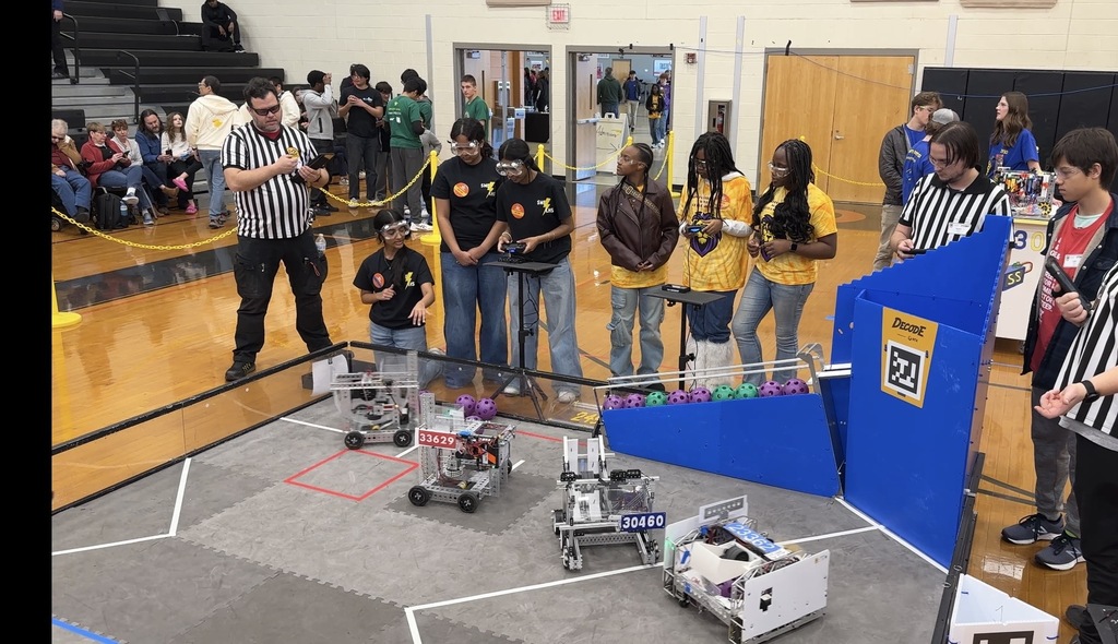 Robotics teams compete in a match at a robotics competition.