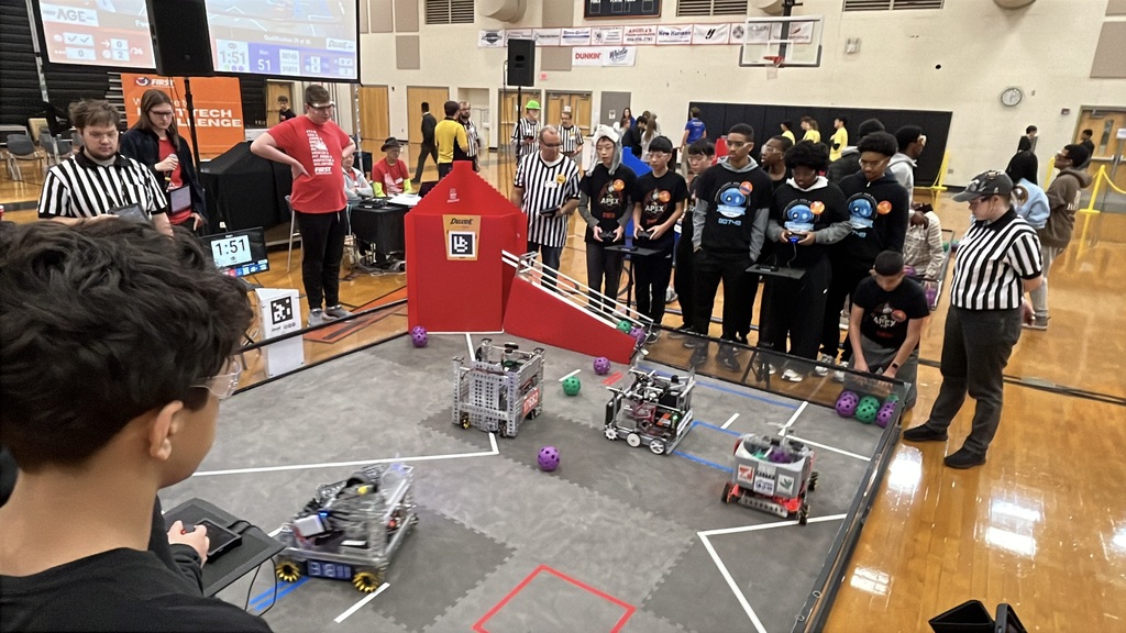Robotics teams compete in a match at a robotics competition.