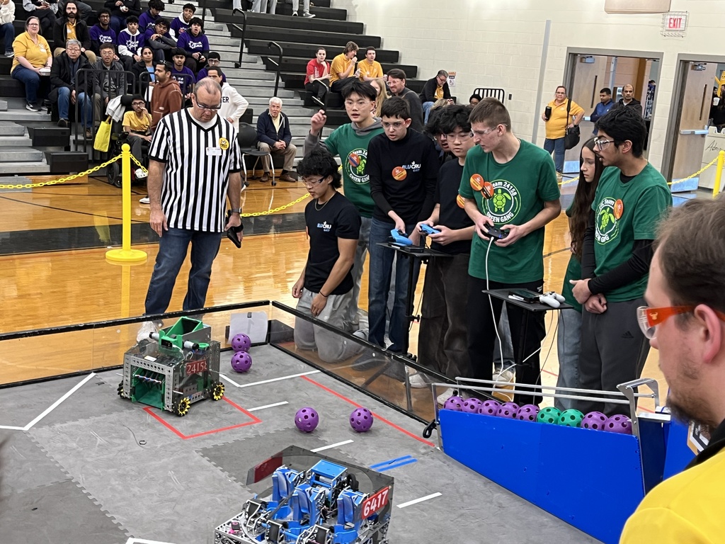Robotics teams compete in a match at a robotics competition.