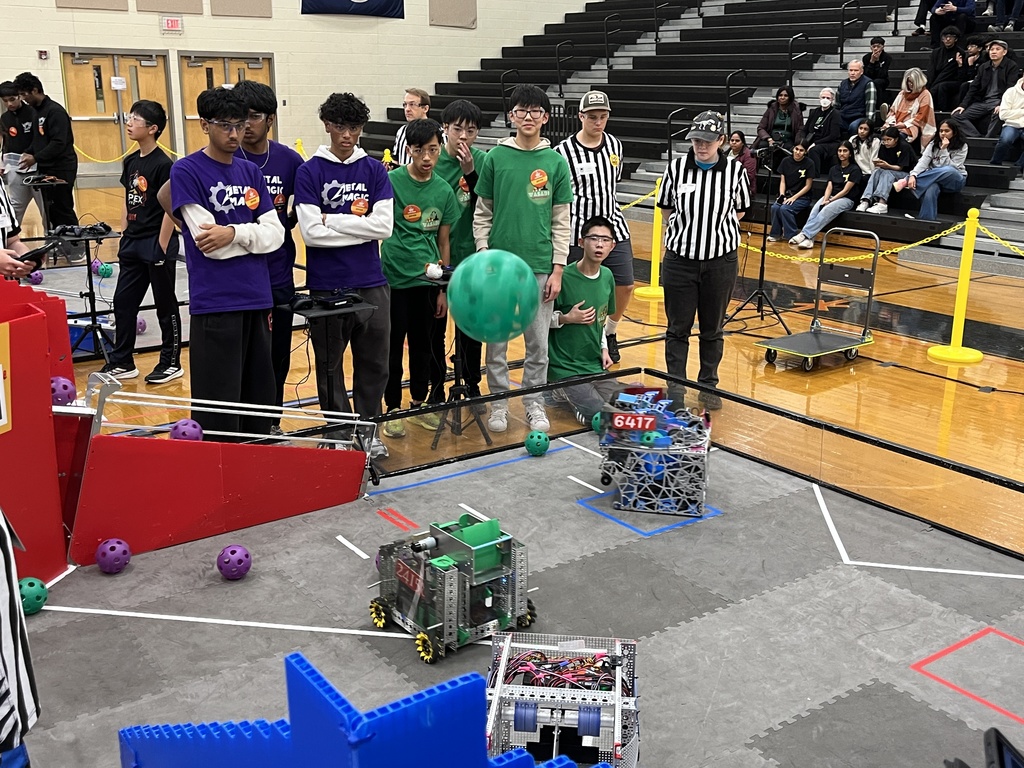 Robotics teams compete in a match at a robotics competition.