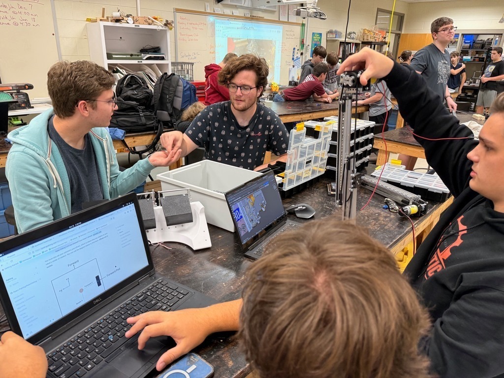 Students in am engineering classroom work on robots.