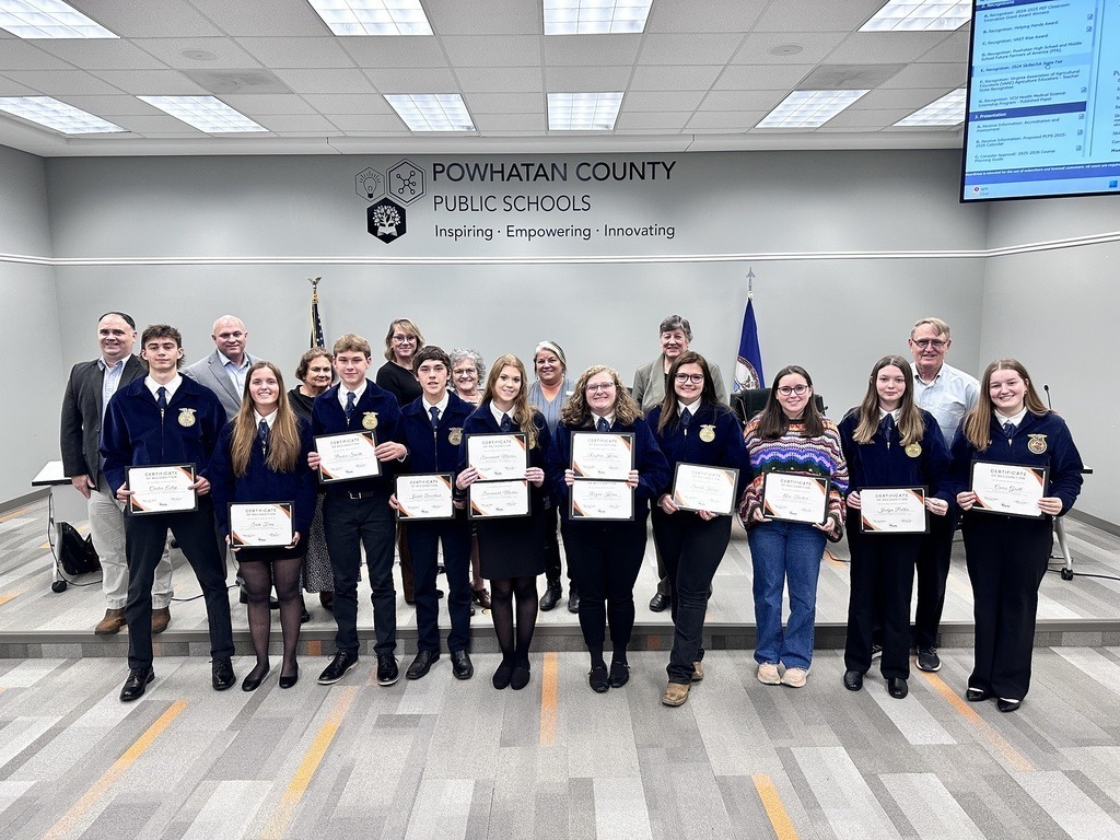 FFA members at a school board meeting pose for a photo with school board members.
