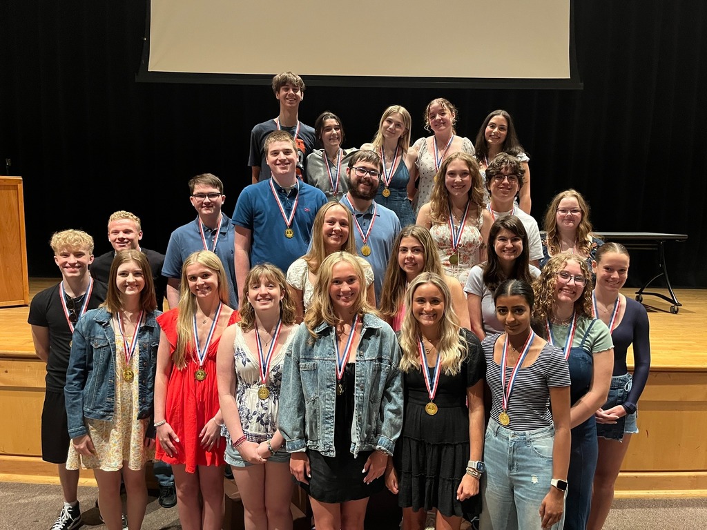A group of students pose for a photo wearing medals.