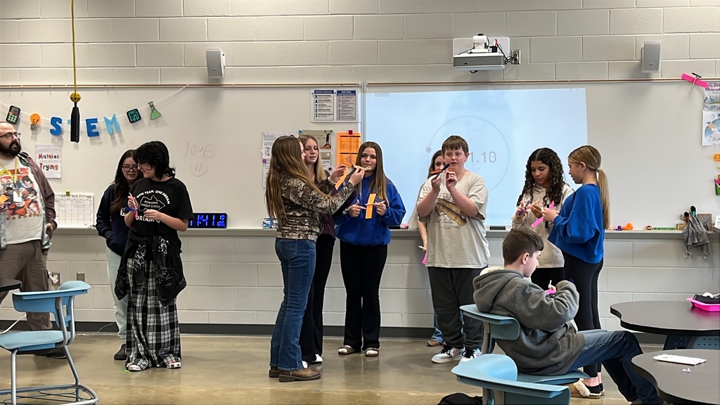 Students throw wind up airplanes their class made on an assembly line.