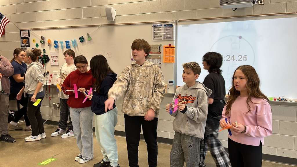 Students throw wind up airplanes their class made on an assembly line.