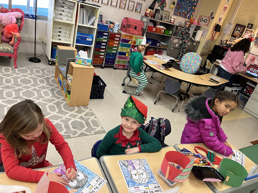 Students in elf hats  work on coloring sheets.