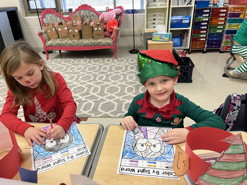 Students in elf hats  work on coloring sheets.