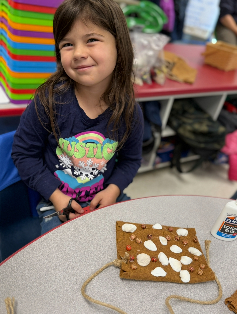 A first grader participates in a colonial craft day activity.  