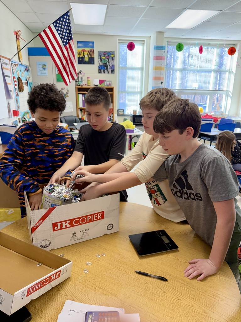 Students in a classroom weigh pop tabs.