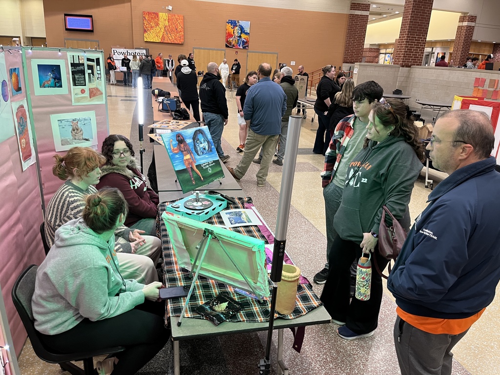 A family visits a booth at a high school information night.
