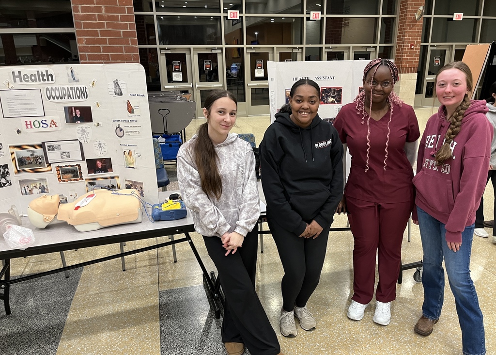 Students pose at a booth at a high school information night.