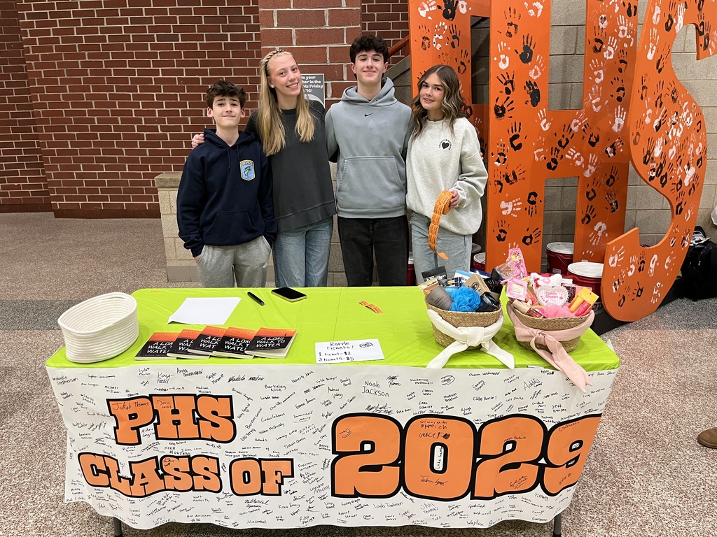 Students pose at a booth at a high school information night.