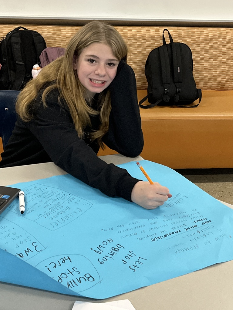 A student works on an anti-bullying poster.