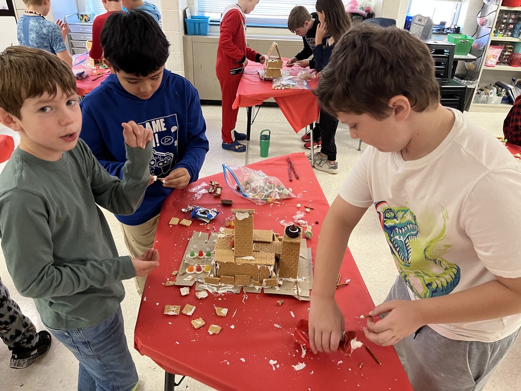 Students in class build gingerbread houses during a holiday party.