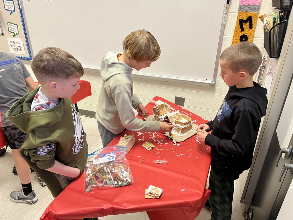 Students in class build gingerbread houses during a holiday party.