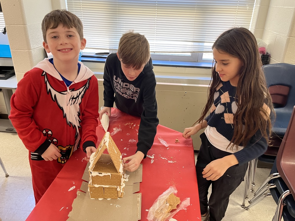 Students in class build gingerbread houses during a holiday party.