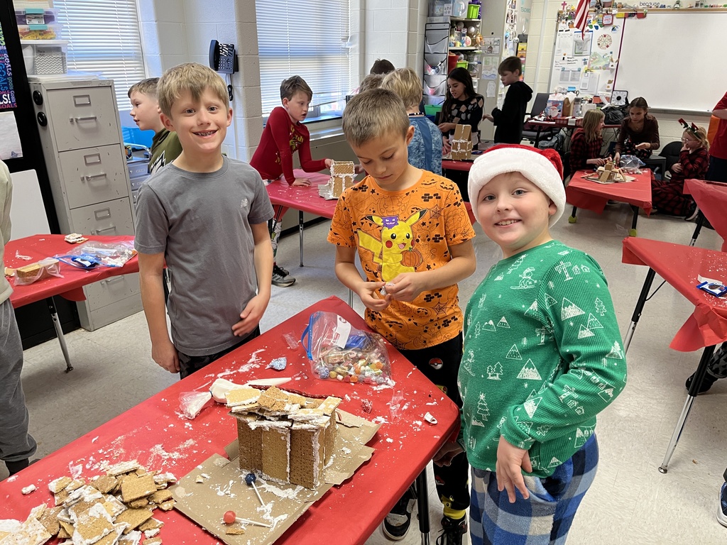 Students in class build gingerbread houses during a holiday party.