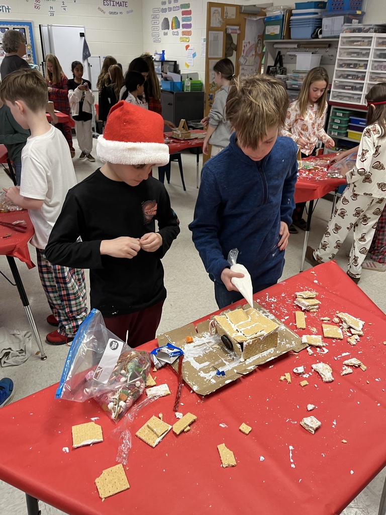 Students in class build gingerbread houses during a holiday party.