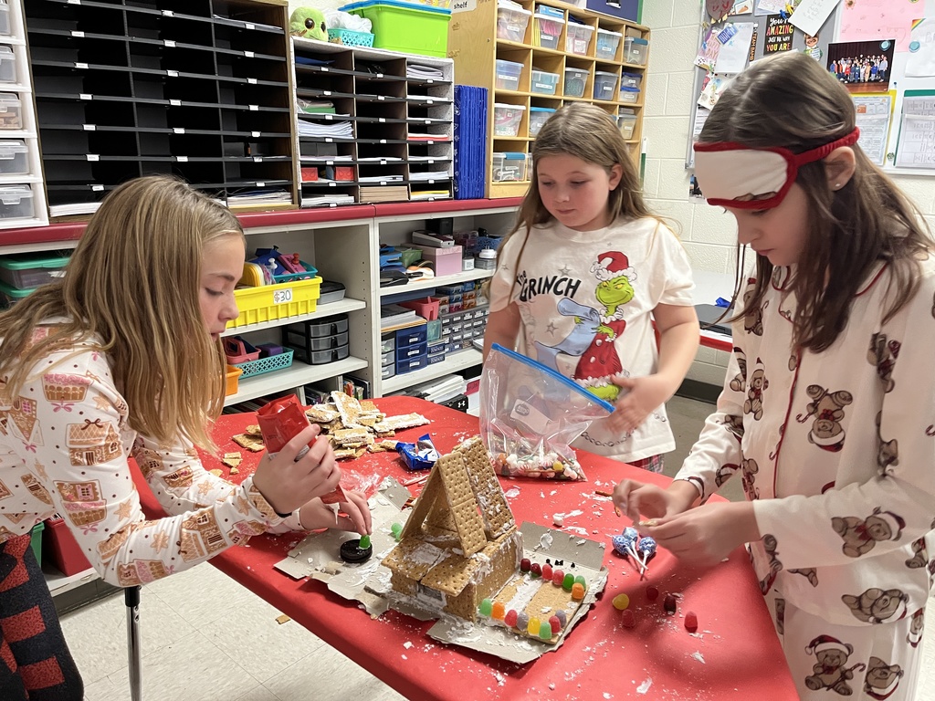 Students in class build gingerbread houses during a holiday party.