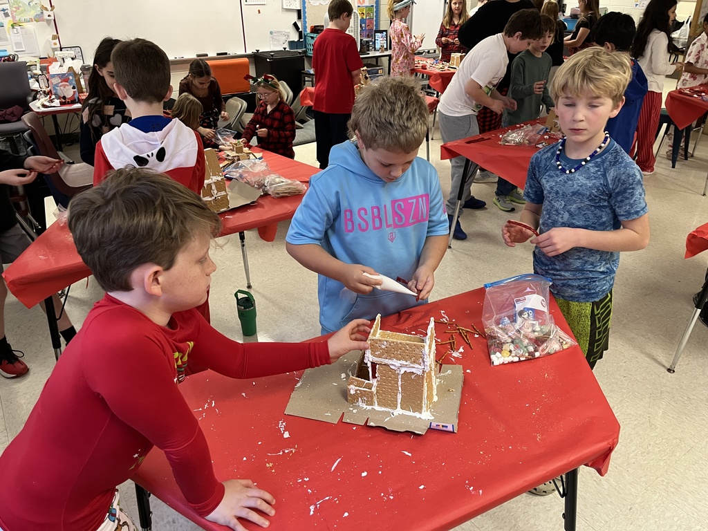 Students in class build gingerbread houses during a holiday party.