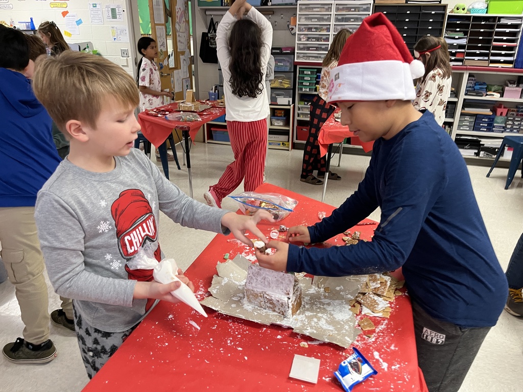 Students in class build gingerbread houses during a holiday party.