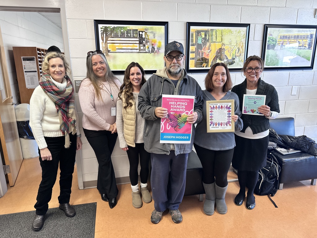 A group of adults pose for a photo. Some hold certificates.
