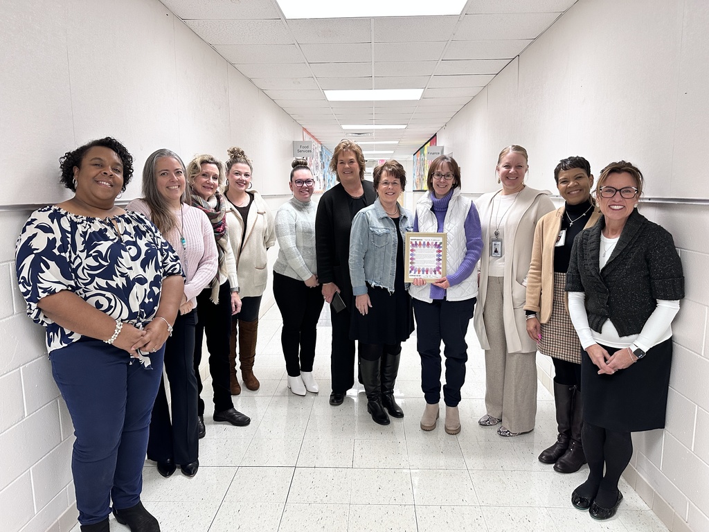 Two adults and a group of students pose for a photo. 