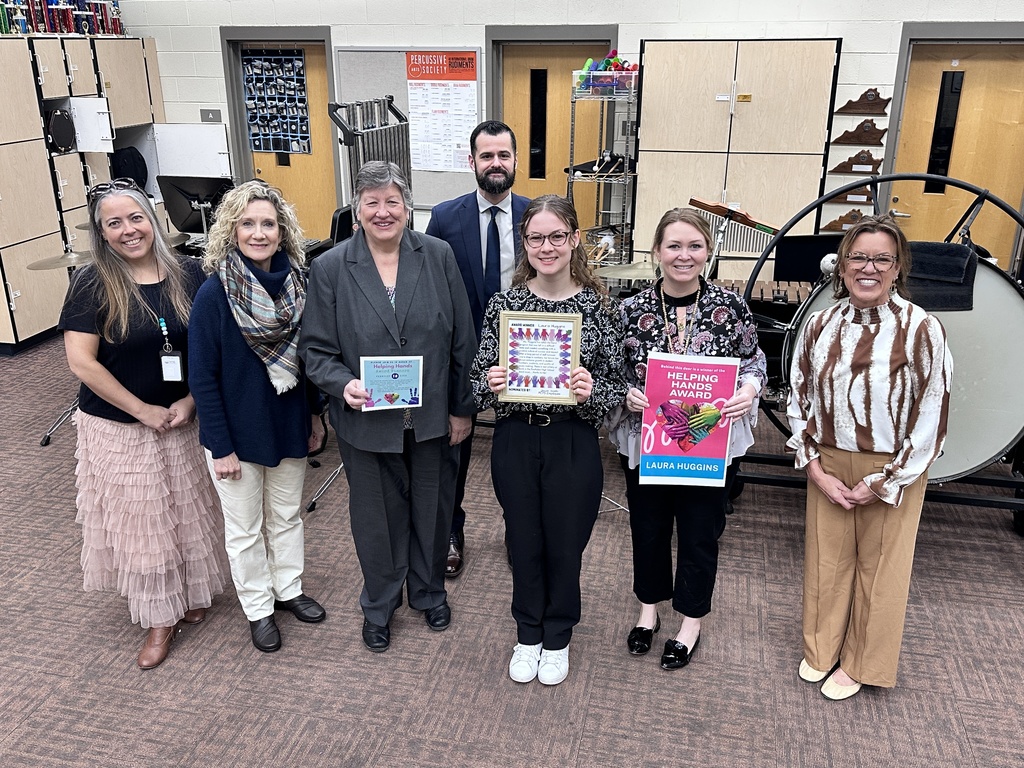A group of adults pose for a photo. Some hold certificates.