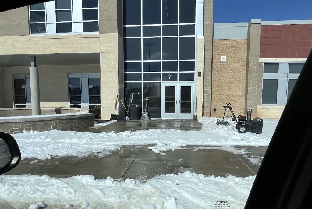 Photo of a school sidewalks that have been partially cleared of ice and snow.