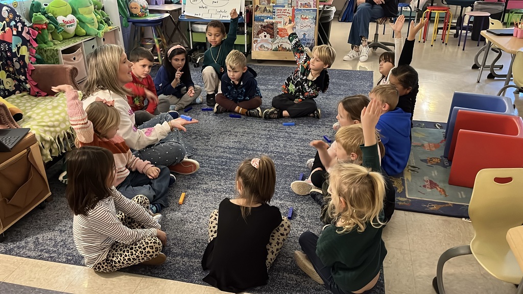 A teacher uses math manipulatives with her students to learn about the parts of five.