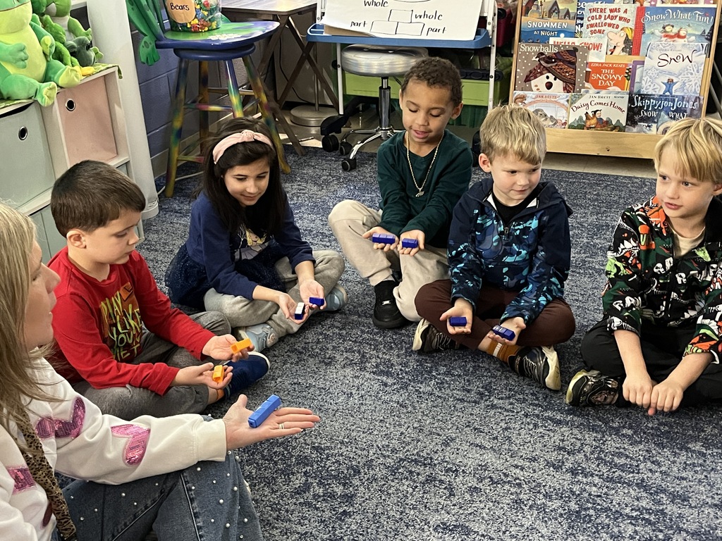 A teacher uses math manipulatives with her students to learn about the parts of five.