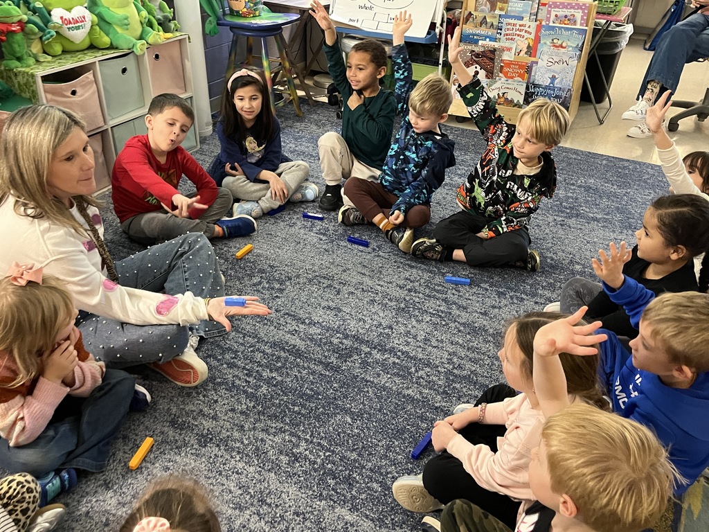 A teacher uses math manipulatives with her students to learn about the parts of five.