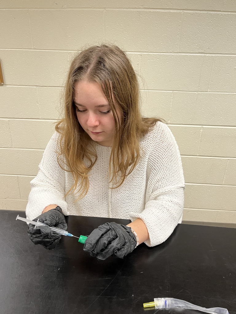 A veterinary science student works on a lab showing how to mix a vaccine.
