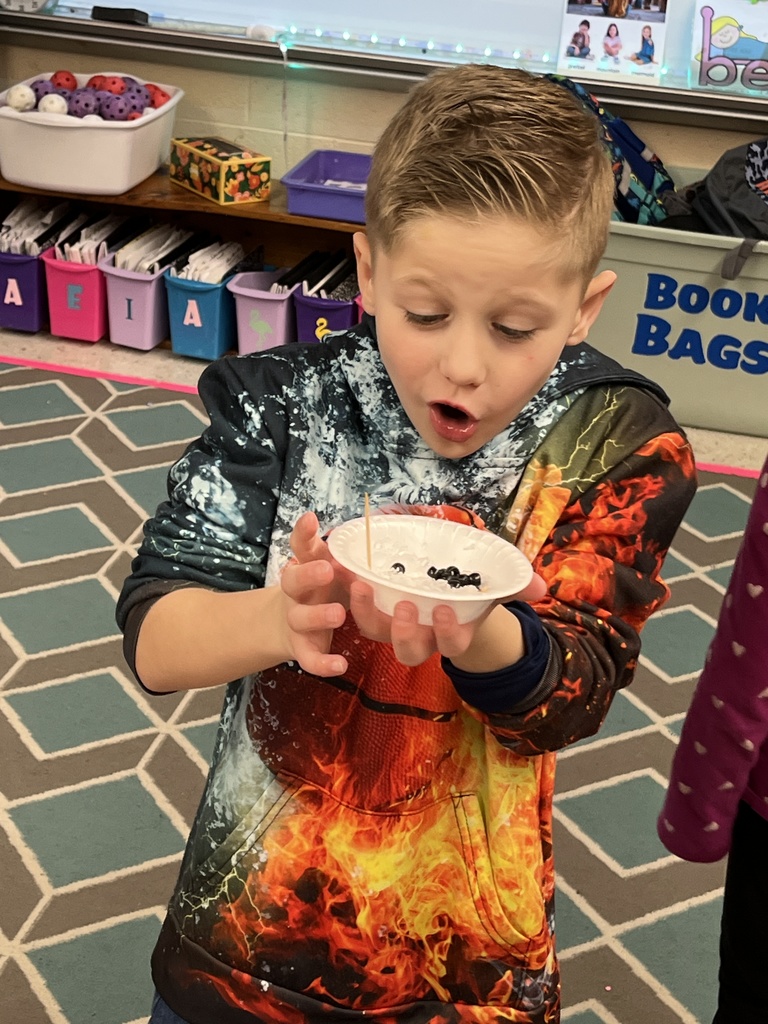 A kindergartener in class makes a personal snowman using crushed ice. 