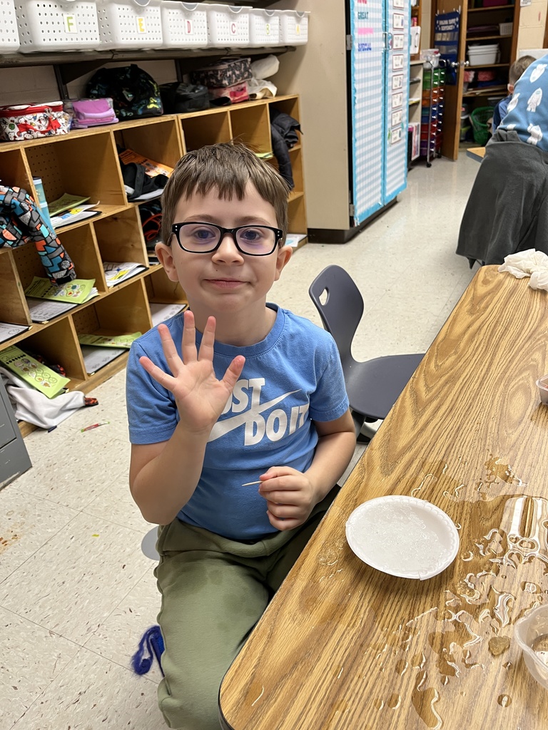 A kindergartener in class makes a personal snowman using crushed ice. 