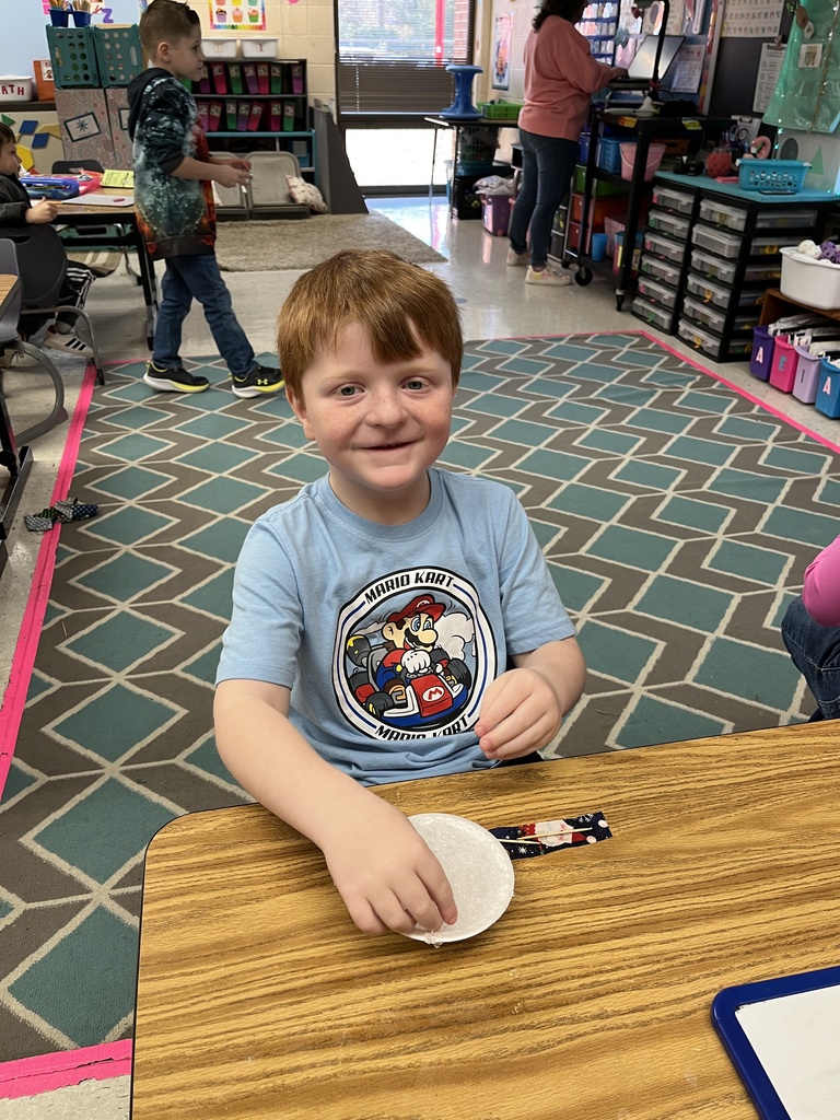 A kindergartener in class makes a personal snowman using crushed ice. 