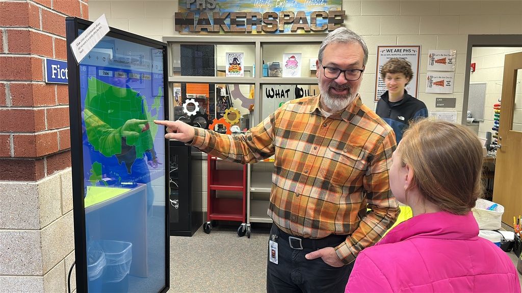 A student participates in a Civil War scavenger hunt in the school library. A teacher helps.
